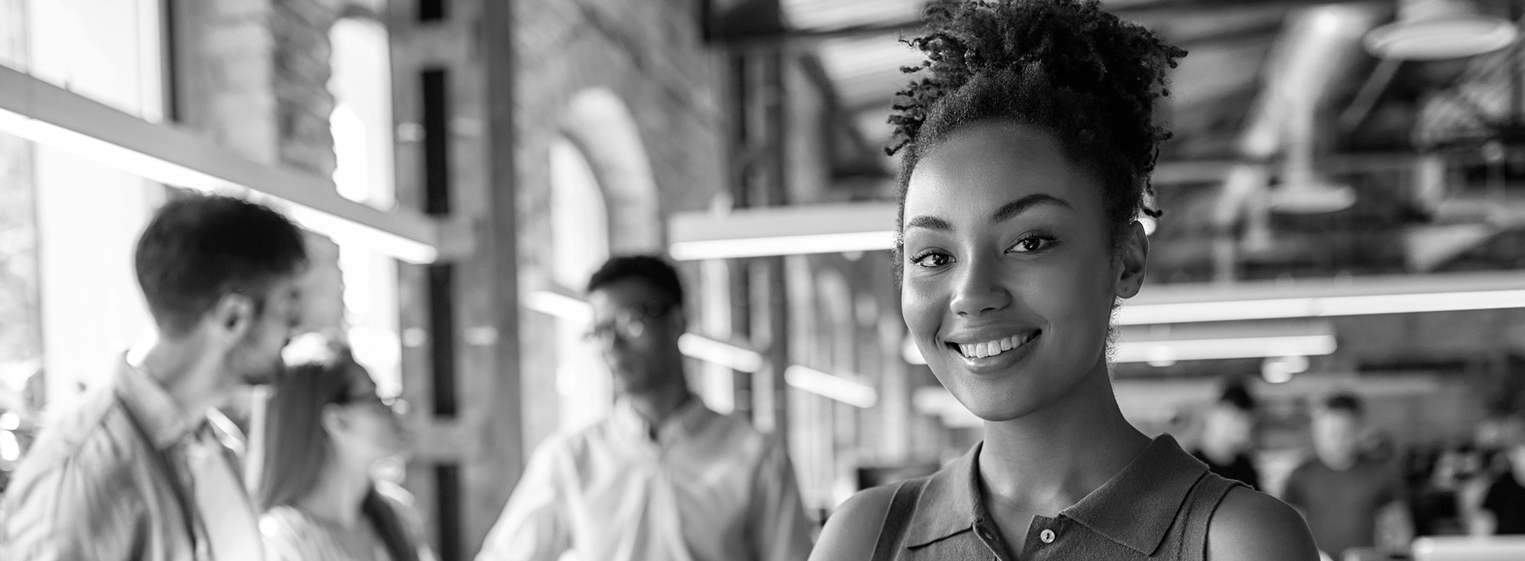 ESS Terms and Conditions Background Hero Faded background of smiling high school girl student in school hallway with unfocused students behind her